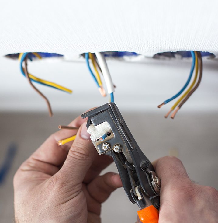 An electrician performing rewiring on a Sydney home