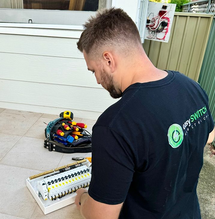 An electrician testing a power point in Sydney